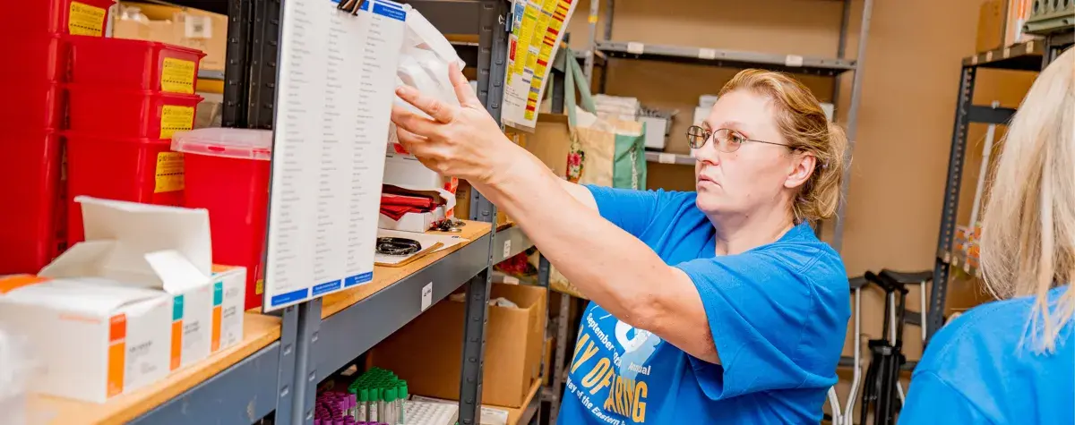 A person volunteers by stocking shelves