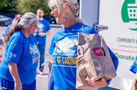 A volunteeer holds a grocery bag